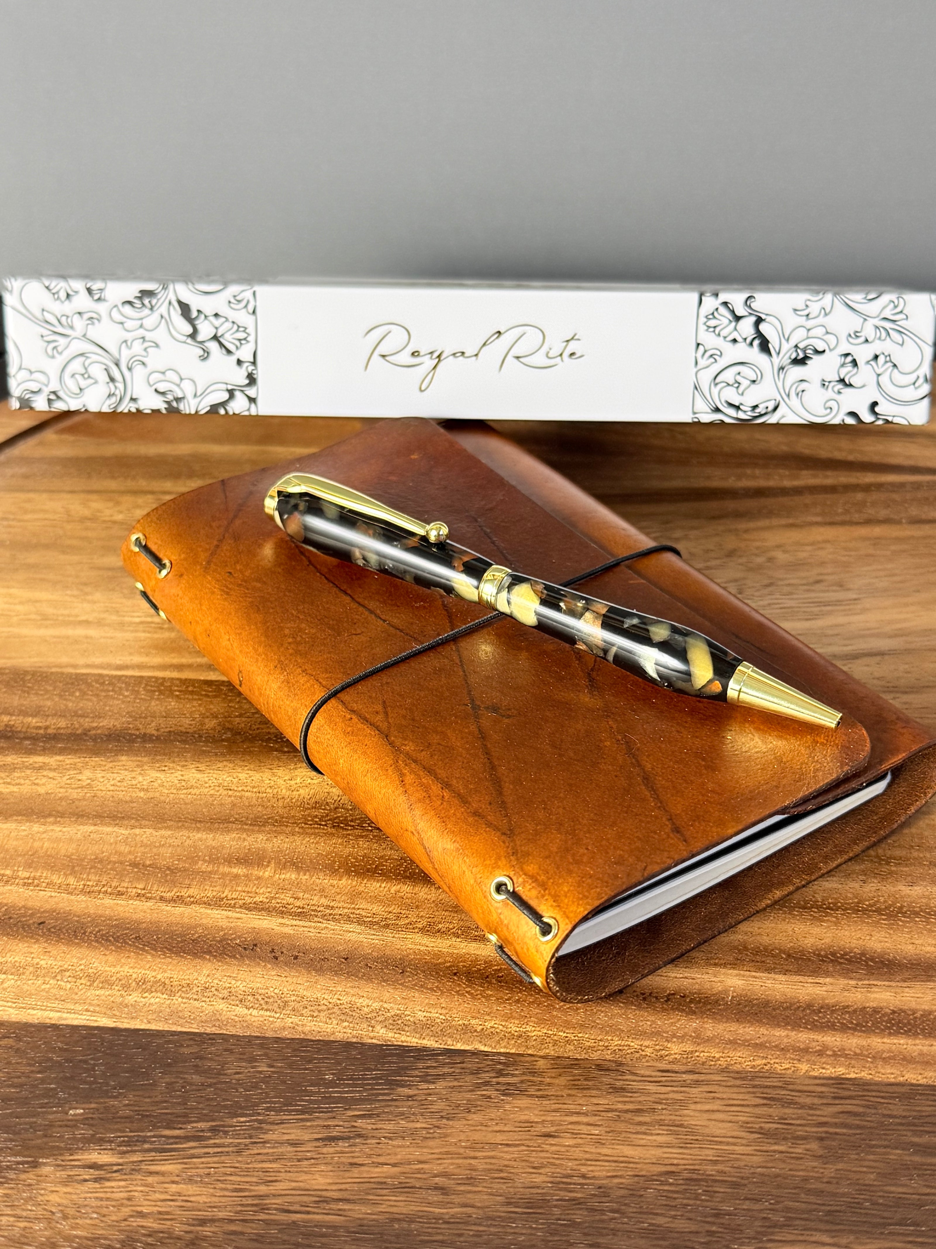 Handcrafted leather journal paired with a writing pen on a wooden desk