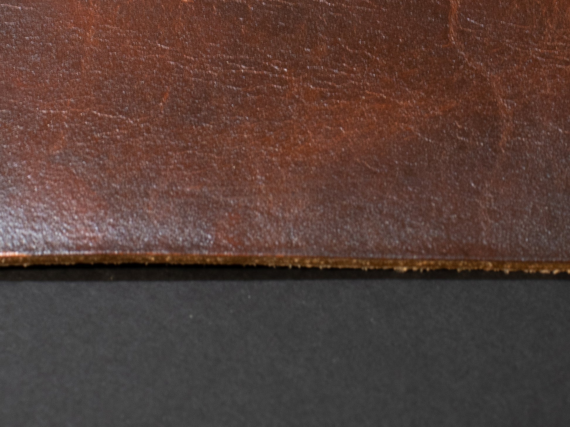 Close-up of brown leather texture on a black background